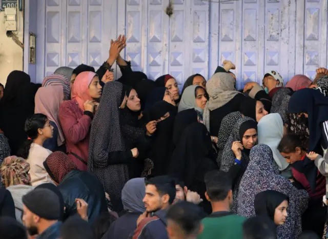 रफ़ाह की एक बेकरी के बाहर खाने के इंतजार में खड़े लोग