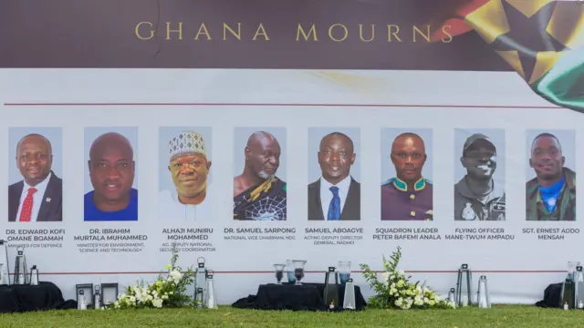 bilboard with the photos of all eight people who died in the 6 August helicopter crash at the ceremonial garden for floral tributes