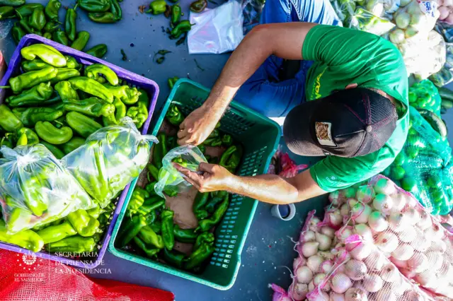 Hombre embolsa chile verde en el agromercado de Ayutuxtepeque, El Salvador.