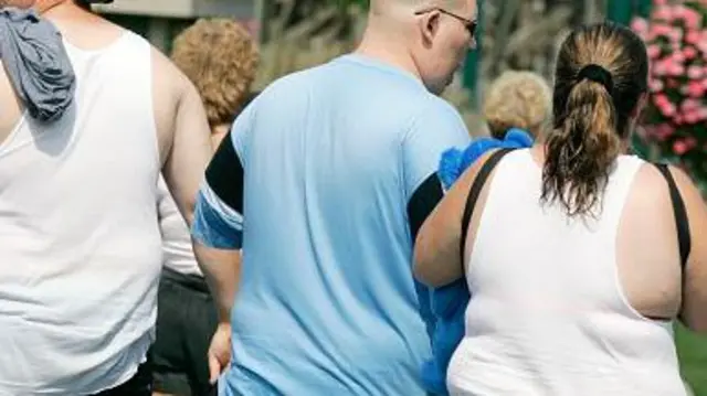 Молоді люди, які мають зайву вагу, йдуть по вулиці.