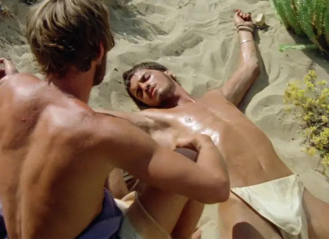 Imágen de la película Sebastiane, de Derek Jarman, en la que aparecen dos hombres con el torso descubierto.