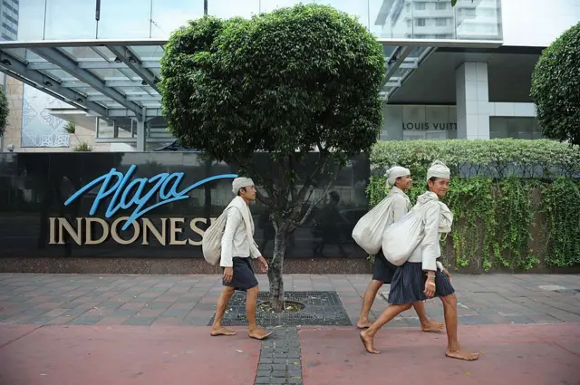 Dalam foto yang diambil pada tanggal 28 Oktober 2012 ini, tiga orang suku Baduy berjalan tanpa alas kaki di ibu kota Indonesia, Jakarta.