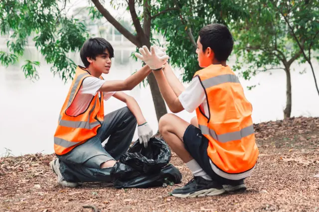 Doğada çöp toplayan iki çocuk.