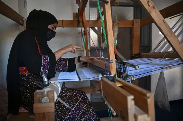 یک زن در پشت دستگاه بافندگی ابریشم 