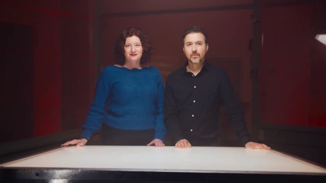 Genetik uzmanı Prof Turi King ve tarihçi Dr Alex Kay bir masa önünde ayakta poz veriyor