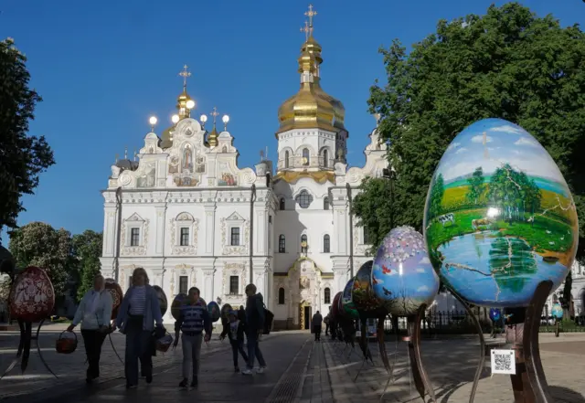 Великдень у Лаврі Києва - люди несуть кошики на фоні Успенського собору