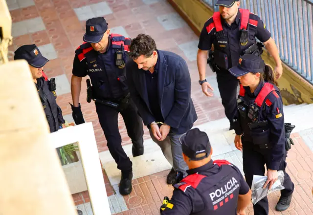 Jonathan Andic esposado y rodeado de policías.