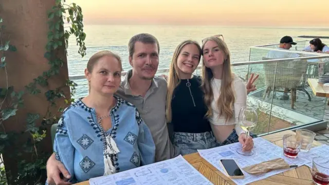 Семейная фотография в ресторане на фоне моря
