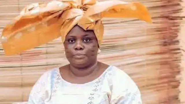 Tosin Olaniyan wọ asọ iro ati buba alawọ miliki, o si we gele to ya ọwọ rẹ si ọtun ati osi. O kọ ila atọwọda si ẹrẹkẹ rẹ mejeeji, ko lo ẹgba ọrun amọ o lo yẹri eti