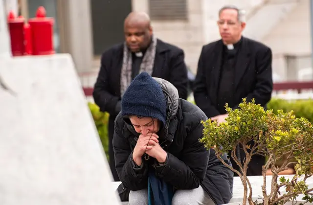 Pipo dey pray in front of di statue of Pope John Paul II for outside Rome Gemelli Polyclinic, wia Pope Francis hospital dey 
