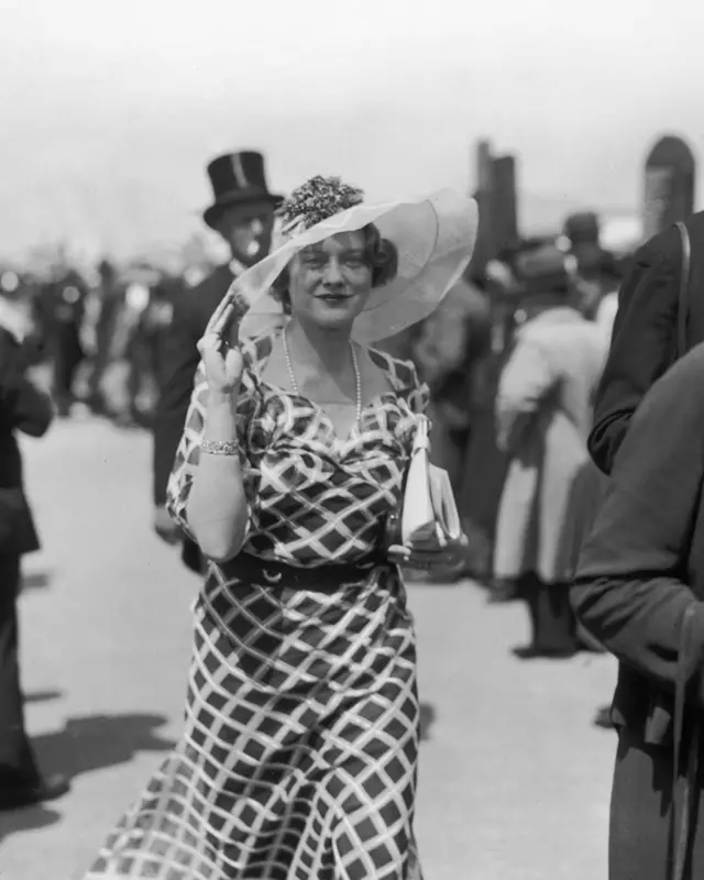 Maureen Constance Guinness, de vestido e chapéu, em meio a uma multidão nos anos 1920