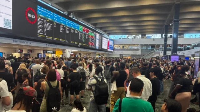 駅構内を埋め尽くすほどの人々が立っている。頭上には運行状況を示す電光掲示板が見える