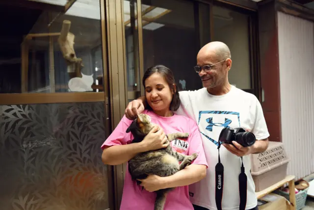 Casal segura um gatinho no colo