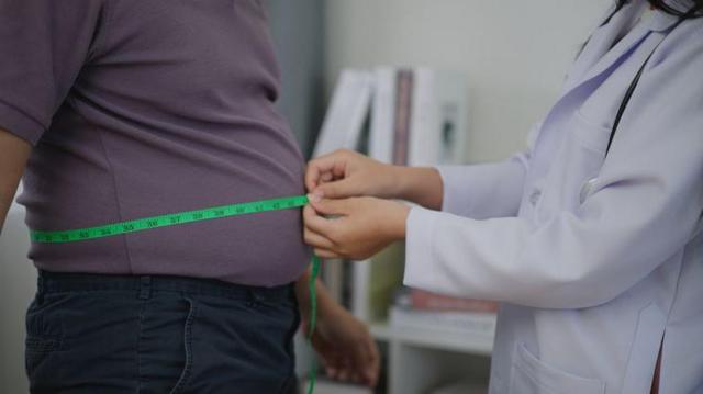 Médico medindo a cintura de um paciente