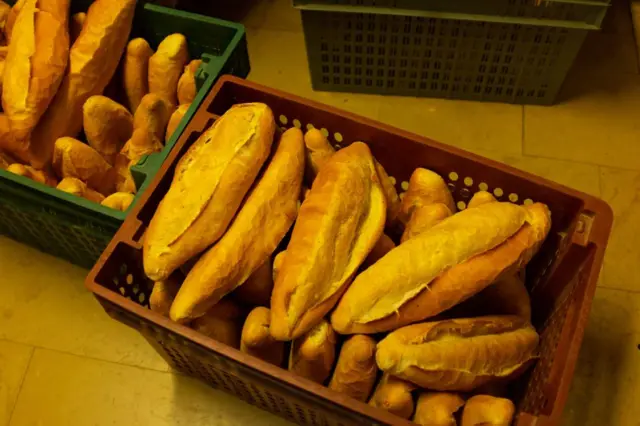 Bir fırının içerisinde iki adet kasanın içersini sıralanmış somun onlarca somun ekmek.