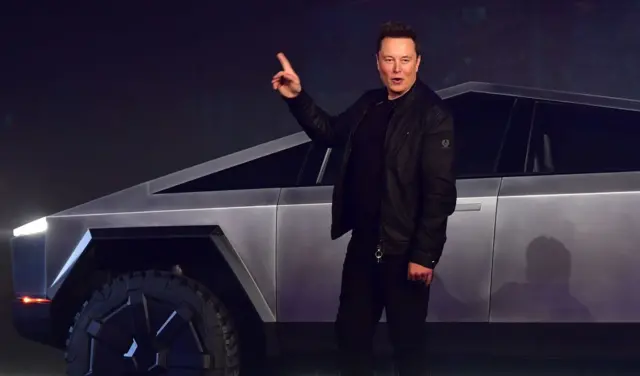 Elon Musk de pie junto a un Tesla Cybertruck