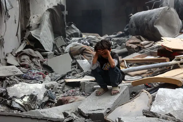 Wiil Falastiini ah oo dhex fadhiya burburka dhisme ku yaalla goob uu duqeyn Israa’iil ka dhacday oo ku taal xaafadda Shujaiyya ee magaalada Gaza, 9-kii Abriil 2025.
