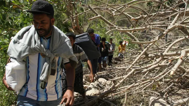 Sejumlah warga membawa bantuan menyusuri jalanan berbatu dari posko bantuan Desa Rokirole ke Desa Nitunglea, Pulau Palue, Kabupaten Sikka, NTT, Rabu (19/8/2026).