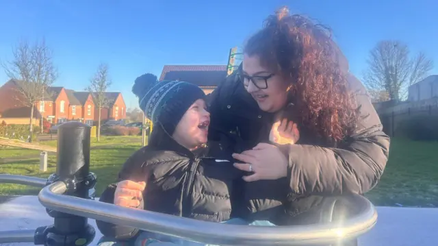 Rupert con su madre Mollie mientras están en una rotonda accesible en Rainworth