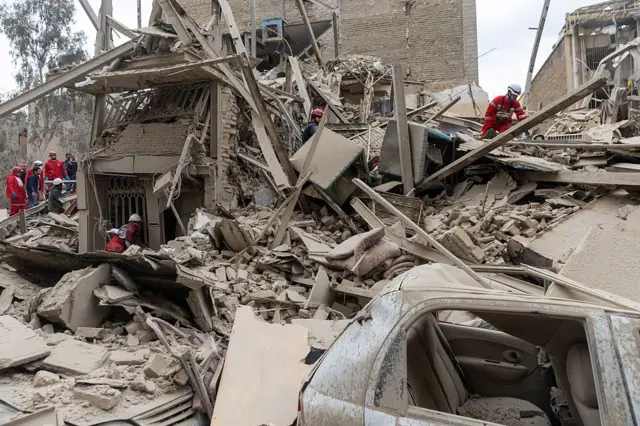 نیروهای امدادی در حال جست‌وجو در میان آوار یک ساختمان مسکونی پس از حمله‌ای در مرکز تهران هستند؛ حمله‌ای که در ۱۶ مارس ۲۰۲۶ و در جریان ادامه حملات مشترک آمریکا و اسرائیل به ایران رخ داد.