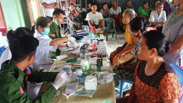 အစိမ်းရောင်ဝတ်စုံနဲ့ ဆေးတပ်ဖွဲ့က အမျိုးသမီး တချို့ကိုဆေးကုသပေးနေမှု 