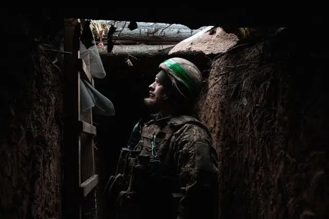 Солдат в окопі дивиться нагору