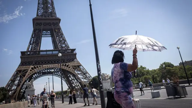 Una mujer en París se protege del calor con una sombrilla