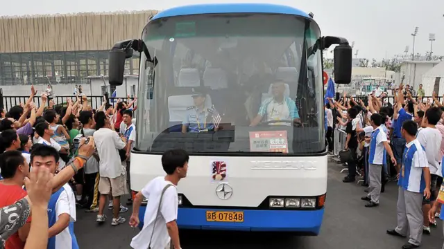 Ônibus olímpico elétrico recebido por uma multidão na China