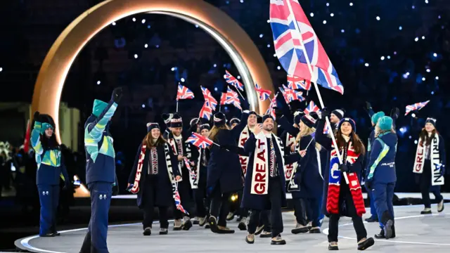 Знаменосец Великобритании Лайла Фир проходит вместе с другими спортсменами во время церемонии открытия Зимних Олимпийских игр «Милан — Кортина 2026» на стадионе «Сан‑Сиро» в Милане, на севере Италии, 6 февраля 2026 года.