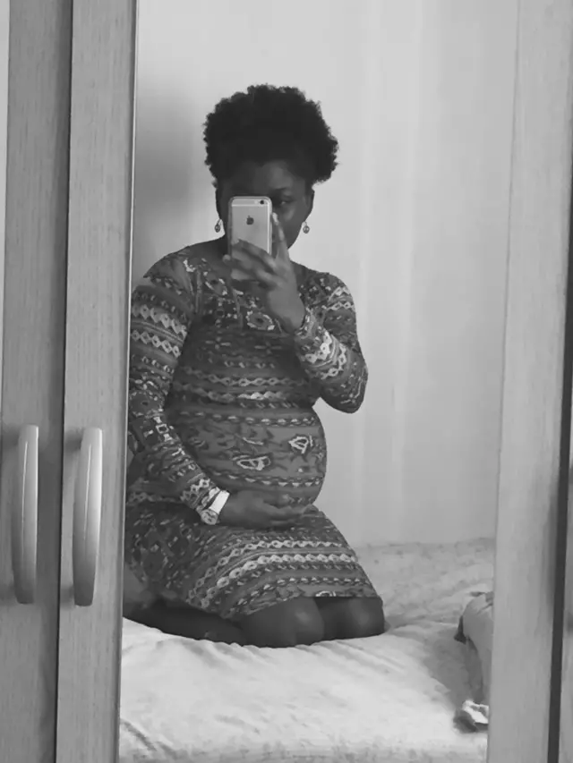 Reine se photographie dans un miroir alors qu'elle est enceinte