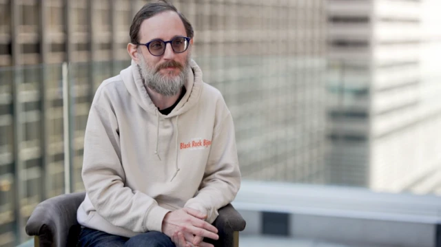 Luzer Twersky sitting in front of skyscrapers