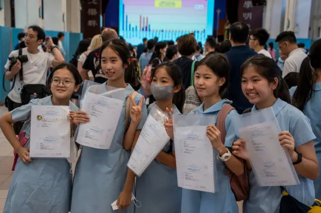 香港某小學發放中一派位結果後一群小六女生舉起派位證留影慶祝（資料圖片）