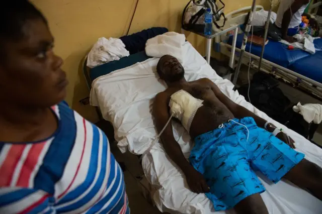 El periodista Reginald Balthazar en el hospital tras ser herido en un ataque de pandillas mientras cubría la inauguración del hospital general de Puerto Príncipe, Haití, el 25 de diciembre de 2025. (Foto: Clarens SIFFROY / AFP) (Photo by CLARENS SIFFROY/AFP vía Getty Images)