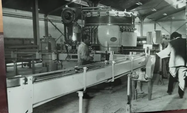 Fabrikanın 1972'deki açılış törenine ait bir fotoğraf. Makineler ve bir işçi görülüyor. 