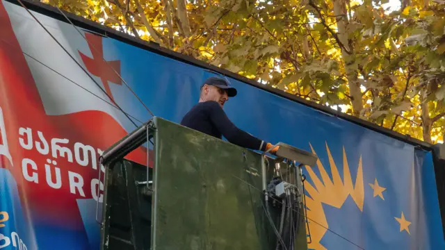Фото с предвыборным плакатом партии «Грузинская мечта»