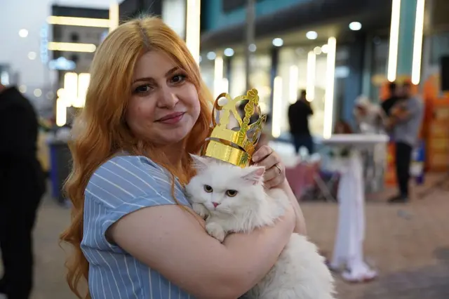 Seekor kucing Persia putih bernama 'Gule Rana', mengenakan mahkota kertas emas, setelah memenangkan festival kucing di Irak.