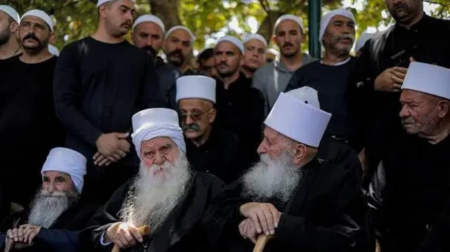 چند نفر از رهبران مذهبی دروزی در بلندی‌های جولان تحت اشغال اسرائیل – ۱۶ ژوئیه ۲۰۲۵ در کنار هم نشسته و حامیان آنها پشت سرشان ایستاده اند