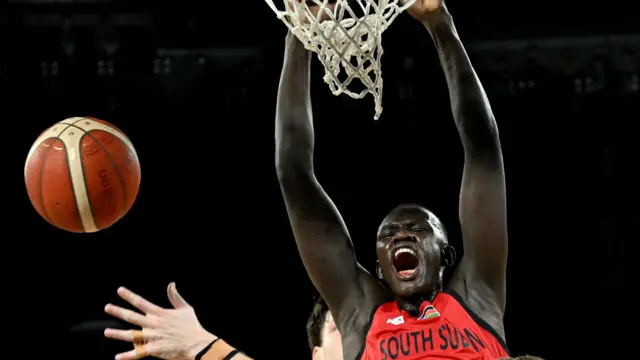 Khaman Maluach screams in celebration as he dunks a basketball
