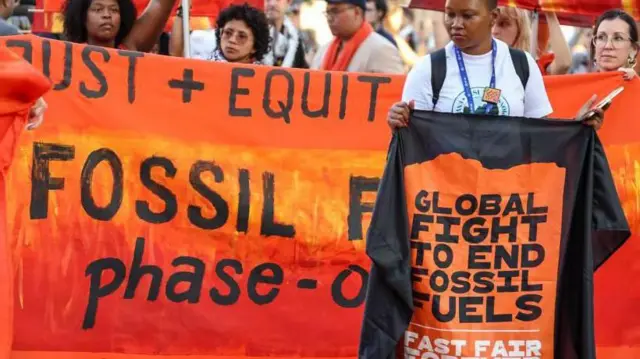محتجون يحملون يافطات ضد استخدام الوقود الأحفوري