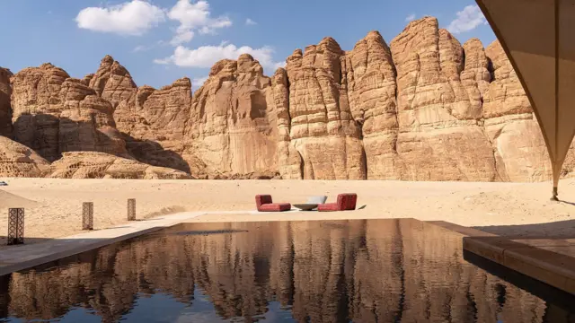 Mesa, poltronas e piscina com vista para rochas desérticas