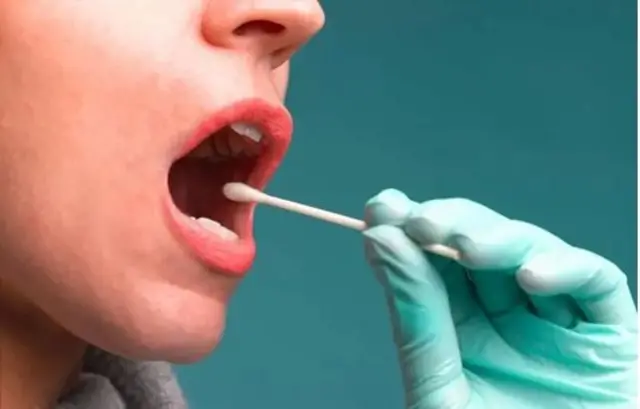 یو ښځينه مخ چې لاس کې یې د غوږونو چوونکی خولې ته نیم دننه کړی دی.