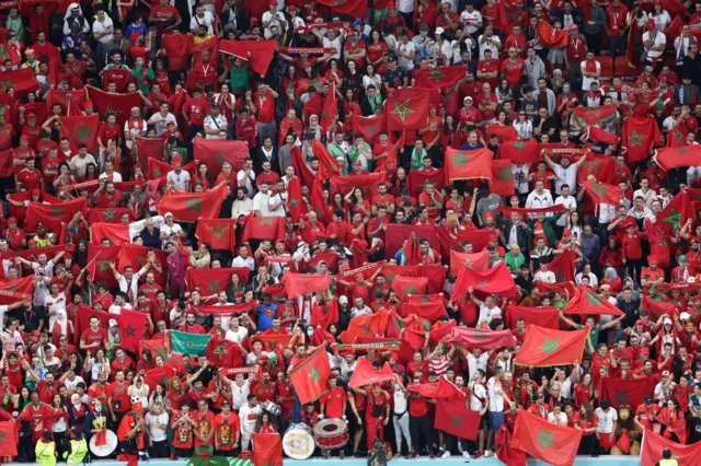 Des supporters marocains brandissent des drapeaux nationaux à l'occasion du match de demi-finale de la Coupe du monde Qatar 2022 entre la France et le Maroc au stade Al-Bayt à Al Khor, au nord de Doha, le 14 décembre 2022.