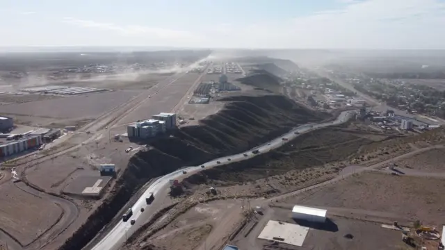 Estrada entre uma cidade arborizada e um planalto árido
