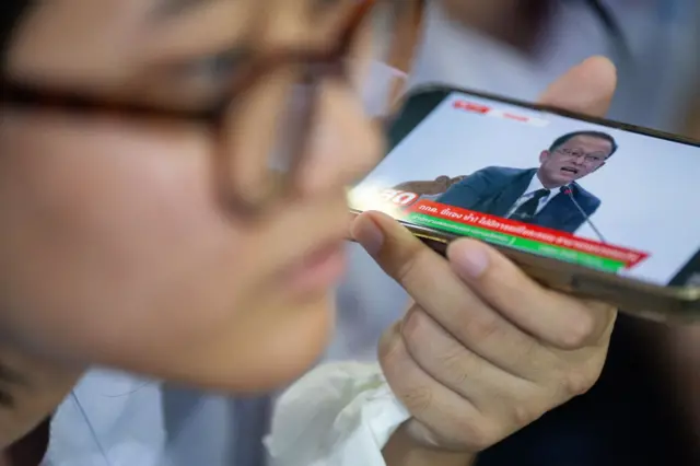 ชาวชลบุรีที่ไปเฝ้าหีบบัตรเลือกตั้งเขต 1 ติดตามการแถลงข่าวของรองเลขาธิการ กกต. เมื่อเวลา 14.00 น. ของวันที่ 10 ก.พ. ซึ่ง กกต. ชุดใหญ่ยังไม่ได้สั่งให้นับคะแนนใหม่