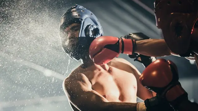 Pugilista dando um soco na cabeça do oponente
