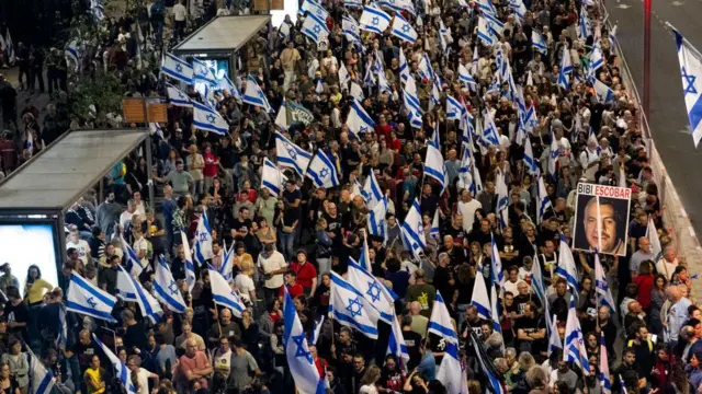Protesters hold signs and flags during one protest wey call for hostages deal wit Hamas
