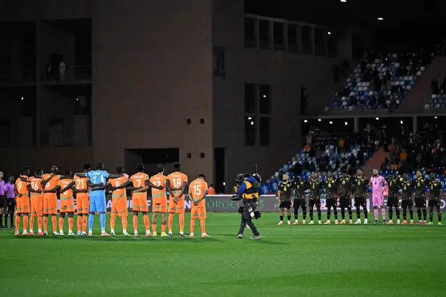 Les joueurs de Côte d'Ivoire et du Cameroun rendent hommage à leur entraîneur français, Jean-Louis Gasset, décédé le 26 décembre 2025, avant le match de football du groupe F de la Coupe d'Afrique des Nations (CAN) opposant la Côte d'Ivoire au Cameroun au stade de Marrakech le 28 décembre 2025. 