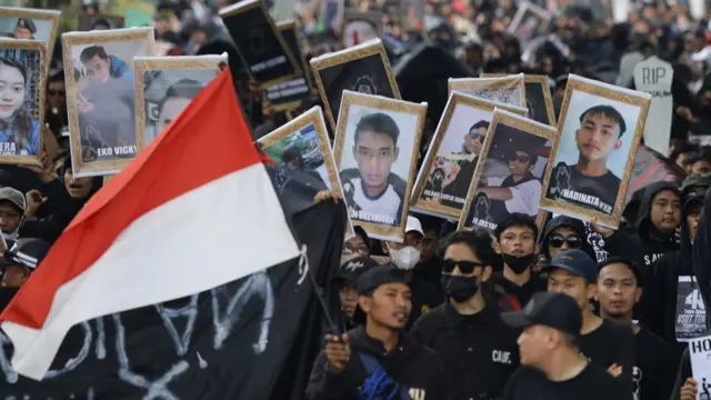 Suporter Arema FC (Aremania) membawa foto korban tragedi Kanjuruhan saat berunjuk rasa memperingati 40 Hari Tragedi Kanjuruhan di Jalan Basuki Rahmat, Malang, Jawa Timur, Kamis (10/11/2022). 