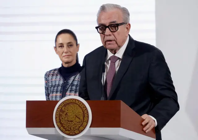 Rocha dando un discurso y unos pasos atrás Sheinbaum.