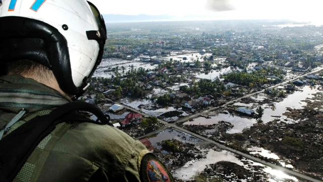 ABD donanmasına ait bir helikopter 2004 tsunamisinden sonra Endonezya'nın Sumatra kenti üzerinde uçuyor